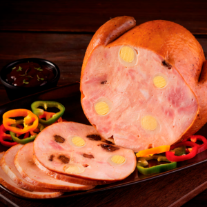 Jamón de pavo entero y en rebanadas con huevo de codorniz y pasas, servido con pimentones coloridos y salsa.